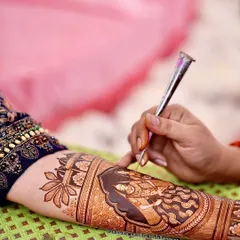 Adding intricate details to a bride's arm. It's the small, fine lines that bring a large figure to life and make the design truly special.