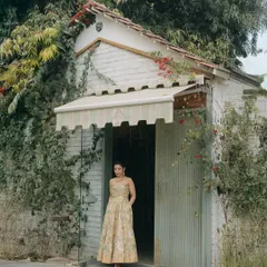 A beautiful portrait of Nikita at her Haldi ceremony, standing in a rustic doorway covered in vines. This image captures a moment of quiet grace amidst the colorful festivities.