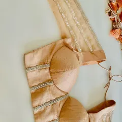 A top-down view of a structured corset blouse in a subtle champagne raw silk. The clean lines are accented with delicate beadwork, offering a contemporary and chic option for the modern bride.