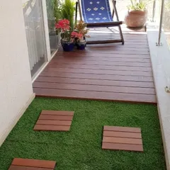 We created a split-level effect on this small balcony by installing a raised WPC deck for seating and an artificial grass area with stepping stones. This design adds depth and functionality to the space.