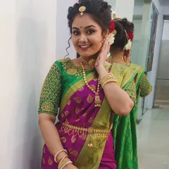 A festive look for Gudi Padwa, showcasing a traditional Maharashtrian hairstyle with an elaborate bun and classic makeup featuring a winged liner and pink lips.
