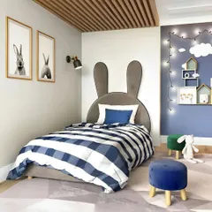 A sweet and simple kids' room with a bunny-themed headboard. The fairy lights and house-shaped shelves on the blue accent wall add a touch of magic.