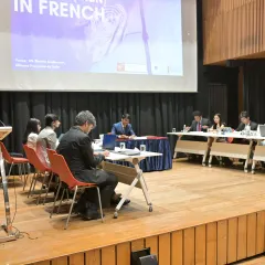 The MUN in session, with students deeply engaged in debate and discussion on topics like cybersecurity and the digital divide, all conducted "en français".