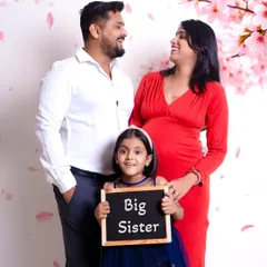 A joyful family maternity announcement in my Gurgaon studio. Including older siblings with fun props like this 'Big Sister' sign makes for a memorable and inclusive family photoshoot.