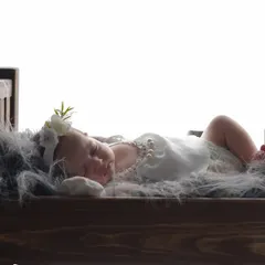 A tiny angel dreaming in a miniature wooden bed. I use a variety of props like this to create sweet, storybook scenes for your newborn's first photoshoot.