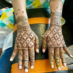 A fully personalized design with the initials 'A' and 'H' on the fingertips and 'Shri' and 'G' on the other hand. The intricate jaal (net) pattern completes this custom piece.
