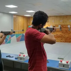 A side by side view of two shooters focusing on their targets. Air rifle shooting is a sport of precision and control, not strength.
