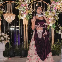 On stage at a beautifully decorated wedding reception. With a grand chandelier and floral arrangements, the setting was perfect for an evening of heartfelt speeches and lively celebration.