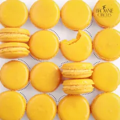 A beautiful flat lay of our Mango Macarons, showcasing their vibrant color and perfect texture.
