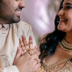 A close-up of the couple's hands and smiling faces after the ring exchange, a perfect symbol of their new commitment.
