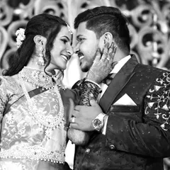 A timeless black and white photo capturing a tender moment between the bride and groom during their wedding reception.