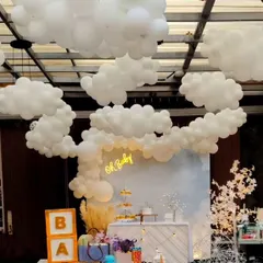A dreamy "Oh Baby" shower with a celestial, cloud-like atmosphere. I created an installation of white balloons on the ceiling to look like clouds, with a simple backdrop and neon sign below.