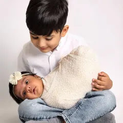 A candid moment where a big brother looks down at his wide-eyed newborn sister. I love capturing these unposed interactions that show their budding relationship.