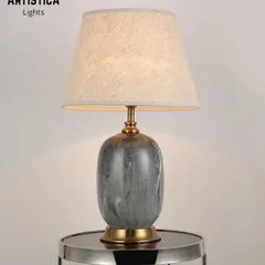 This contemporary lamp features a ceramic base with a grey marble-effect pattern and a simple fabric shade. It includes a dual-lit feature, allowing both the base and the shade to glow for added ambiance.