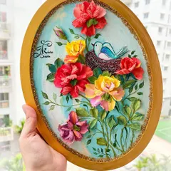A beautiful oval panel with a bird's nest theme. A tiny bluebird sits in its nest, surrounded by a lush arrangement of red, yellow, and pink sculpted roses.