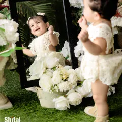A baby discovers her own reflection in the mirror. Using props like mirrors can lead to wonderful, interactive, and joyful moments during a shoot.