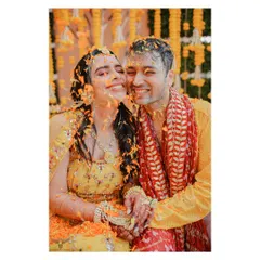 Drenched in love, laughter, and flower petals. This candid shot from a Haldi ceremony captures the couple in a moment of pure, uninhibited joy.