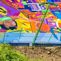This part of the mural depicts the energy of Mumbai, with its iconic architecture and the spirit of the game. The colors are bold and electric, reflecting the city's vibe.