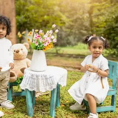 Twins enjoying a teddy bear picnic in the park. Outdoor sessions are great for energetic toddlers who love to run and play.
