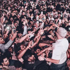 DJ Snake gets up close and personal, surrounded by a massive crowd of fans all trying to get a photo.