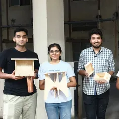 This group of makers with their new creations, including a bird feeder, a small stool, and a couple of wooden boxes. Everyone starts as a beginner and leaves with a finished project.