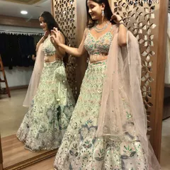 A full mirror shot showing the beautiful colors and the flow of this light green lehenga.