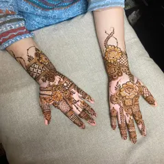 A fusion design that combines bold Arabic flowers on the palm with geometric Indian patterns on the wrist and fingers.