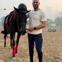 A playful moment captured during a solo photoshoot, with the rider placing his helmet on the horse's head. Our horses are patient and good-natured.