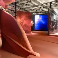 An expansive view of the 'Terra' installation, showing how the giant leaf sculptures interact with light and surrounding digital displays. The piece creates a metaphorical landscape that feels both familiar and otherworldly.