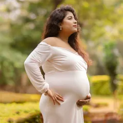 A serene solo portrait of a mother-to-be, cradling her bump in a beautiful garden. I use soft, natural light to emphasize the glow and beauty of pregnancy.