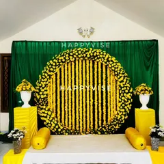 A classic Haldi ceremony setup, vibrant with traditional marigold flower arrangements against a rich green backdrop. This design brings out the joyful and sacred feeling of the 'sambharama'.