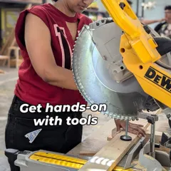 A member gets hands-on experience with a mitre saw, making a precise angled cut on a wooden plank. Our woodworking zone is perfect for everyone, whether you're a complete beginner learning the basics or an experienced crafter working on a complex build.