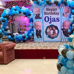 Who's the boss? Your little one is. Our Boss Baby theme is perfect for a first birthday, featuring a custom backdrop with the birthday boy's name and photo, surrounded by a stylish blue, black, and white balloon arch.