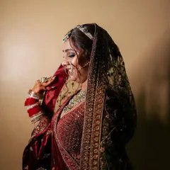 A close-up of a bride in a rich velvet maroon lehenga. This shot highlights the detailed embroidery on the blouse and the heavy dupatta, a signature of our premium bridal rental range.