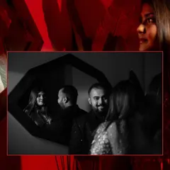 A creative black and white reflection shot of a couple in a mirror, surrounded by a bold red frame, adding an artistic touch to their party look.