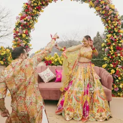 A playful moment between the couple during their Haldi carnival. Their coordinated printed outfits add to the fun and festive atmosphere.