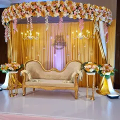 A classic and elegant stage for a 25th wedding anniversary. I used gold drapery, crystal chandeliers, and lush floral arrangements to create a royal look, complete with a vintage-style chaise lounge for photos.