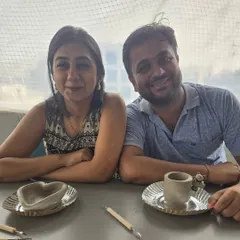 After the wheel, it's time for hand-building. This couple proudly shows off their creations, a small heart-shaped dish and a cute mug, ready to be painted.