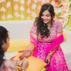 A glowing Mehendi look. I created a soft, romantic makeup look with a shimmery pink eye to complement her bright outfit, ensuring she felt beautiful while getting her henna done.