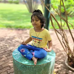 A young student finds her focus in an outdoor meditation. Teaching children to connect with their breath in a natural setting helps them develop self awareness and a sense of calm.