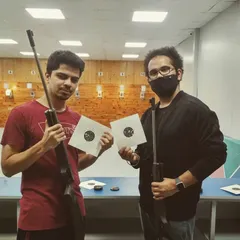 Two of our guests proudly display their target sheets after a successful session. The satisfaction of seeing your shots group together is a key part of the experience we love to share.