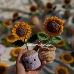 Holding two of our smiling sunflower pots. We offer the pots in different colors like lilac and natural brown. They are a small, joyful piece of handmade art.