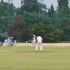 An action shot from the KSCA Under-12 League match between Lions Cricket Club and Eleven Brothers CC, with the official KSCA scoreboard in the background.