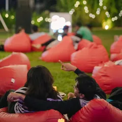 A couple enjoying a movie night together, pointing at the screen. It's a perfect date night idea.