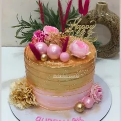 Our bestselling pink and golden design. This single-tier whipped cream cake is perfect for birthdays and anniversaries, featuring a beautiful ombre effect and decorated with fresh flowers, pink spheres, and dried grasses.