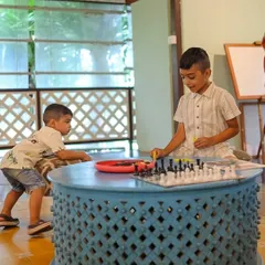 Brothers enjoying a game of chess, a quiet moment of sibling bonding and strategic fun.