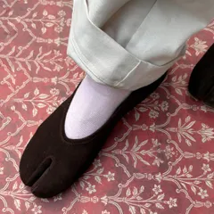 The rich texture of my brown suede DUPE Tabi flat, set against a traditional pattern. This shoe is about bringing together different worlds, creating a piece that feels both familiar and entirely new.