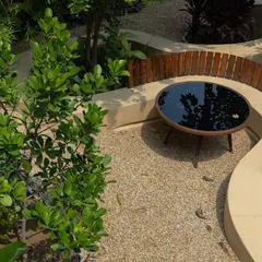 **Playfold, Ahmedabad:** An overhead view of a seating nook created by the curving bench. The design carves out intimate spaces for conversation and relaxation, surrounded by lush greenery.