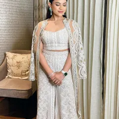 A full view of this gorgeous all-white ensemble. The makeup is subtle yet polished, enhancing her features without overpowering them.