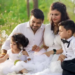 A complete family, all dressed in white, enjoying a moment together in the soft sunlight. We love creating these natural light family portraits that feel dreamy and real. These are the frames that will hang on your walls for years.